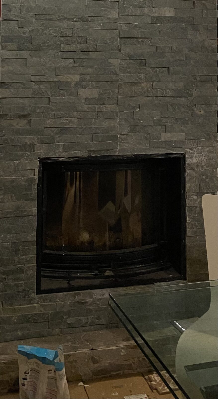 Detalle del revestimiento de piedra en chimenea con estufa